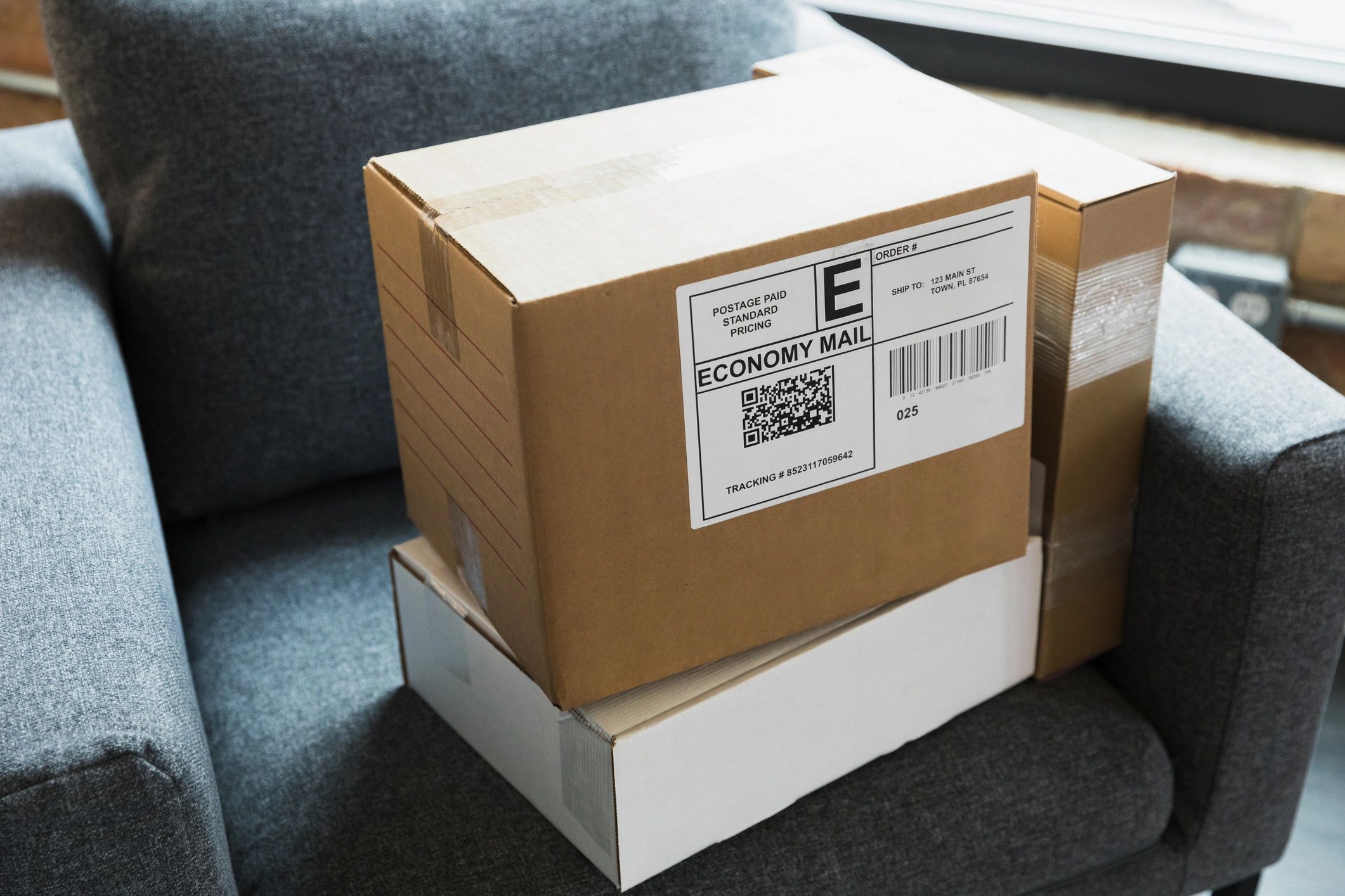 Two labeled shipping boxes stacked on a chair, representing shipping and returns policies.