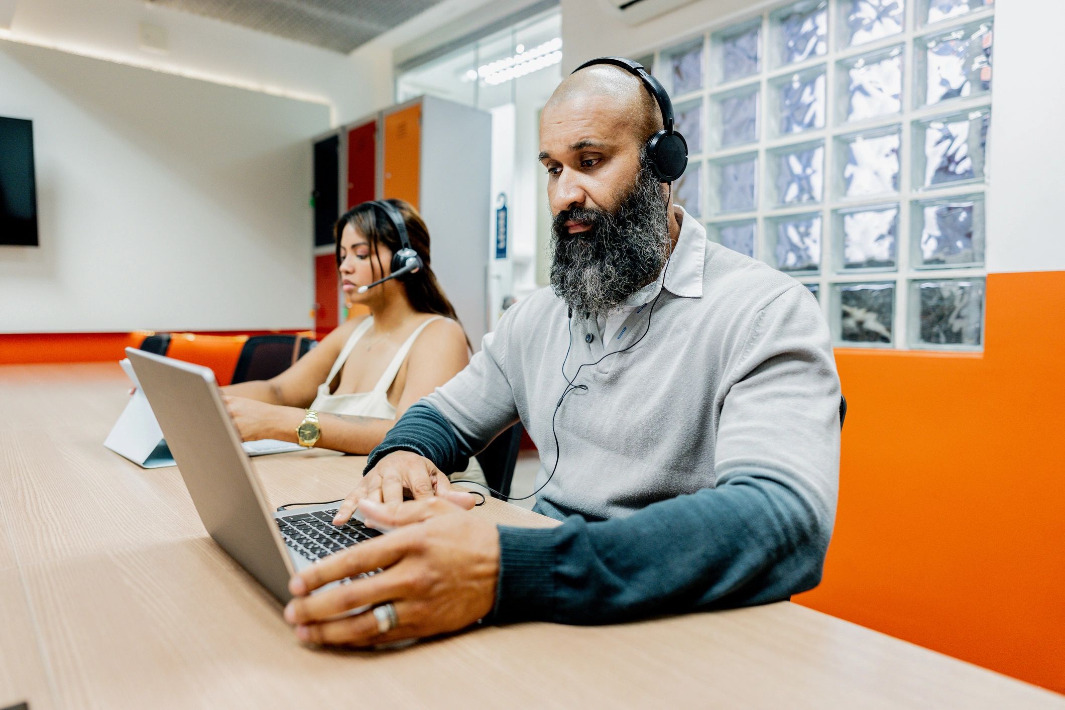 Customer service representative working at a laptop with headset
